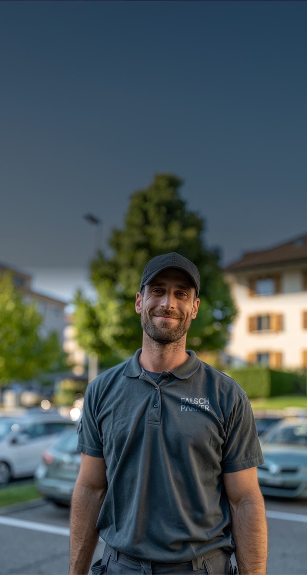 Falsch-Parker parking attendant in uniform in front of parked vehicles at dusk